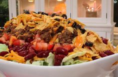 a large bowl filled with taco salad and tortilla chips on top of it