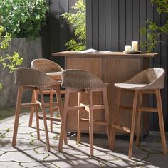 three wicker bar stools sitting in front of a counter with candles on it