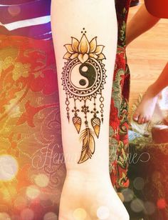 a woman's arm with a tattoo on it and a yin sign in the center