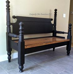 a black bench with wooden slats on the bottom and sides, in front of a beige wall