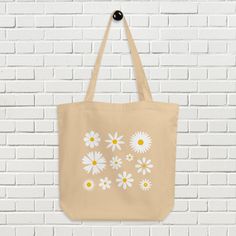 Whether you're a flower lover, an eco-conscious shopper, or simply adore the simplicity and beauty of daisies, this bag is a must-have addition to your collection. With ample space and sturdy handles, it is perfect for carrying your groceries, books, or daily essentials. It's a versatile addition to your style and a sunshine-filled companion for any outing. * 100% certified organic cotton 3/1 twill * Fabric weight: 8oz/yd² (272 g/m²) * Dimensions: 16″ × 14 ½″ × 5″ (40.6 cm × 35.6 cm × 12.7 cm) * Eco-friendly Flower-shaped Everyday Bag, Eco-friendly Everyday Bags With Floral Print, Eco-friendly Everyday Bags For Mother's Day, Eco-friendly Bags For Spring Gifts, Eco-friendly Everyday Spring Bag, Eco-friendly Floral Print Spring Bags, Eco-friendly Flower Shaped Bags For Spring, Eco-friendly Spring Gift Bags, Eco-friendly Flower-shaped Bags For Spring