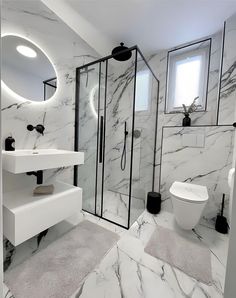 a white bathroom with marble walls and floors