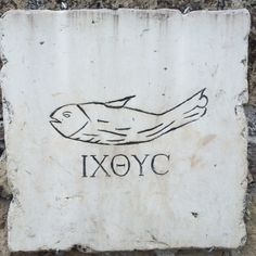 a stone plaque with an image of a fish and the word iyoc on it