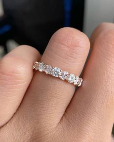 a woman's hand with a wedding band on it, and the ring has three stones