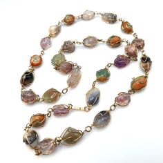 *Description: This is a beautiful gemstone wire wrapped vintage necklace from the 1960s to 1970s.  I tested the stones with the Presidium Gem Tester and each stone tested as a gemstone. Some of the stones include amethyst, jade, agate, and carnelian. The gold plated wire is wrapped around each gemstone in a very artistic manner. This would be a great necklace for your collection to wear for years to come. This would be a great addition to your vintage jewelry collection or make a great vintage gift! *Approximate Measurements: Length - 30 Inches, Weight - 2.2 Ounces *Condition: Very good vintage condition.  Will see signs of wear under magnification. See photos for details. *Hallmark:  Unsigned *Item # 6031 Please look at the photos carefully as they are a part of the description. We are mo Vintage Gemstone Necklace For Healing, Vintage Healing Gemstone Necklace, Vintage Multicolor Wire Wrapped Jewelry, Vintage Natural Gemstones, Vintage Crystal Necklaces For Jewelry Making With Natural Stones, Vintage Multicolor Gemstone Beads And Cabochons, Vintage Crystal Necklaces For Jewelry Making, Vintage Wire Wrapped Necklace For Healing, Vintage Multicolor Agate Jewelry