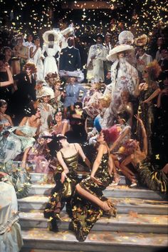 a group of people standing on top of steps with confetti in the air