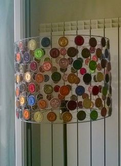 a lamp that has buttons on it hanging from the ceiling in front of a window