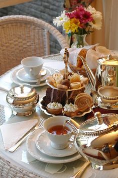 the table is set with tea and desserts