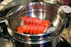 lobsters are being cooked in a pot on the stove