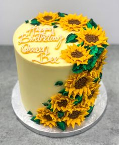 a birthday cake decorated with sunflowers on a plate