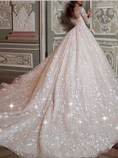 a woman in a wedding dress is standing near a wall and posing for the camera