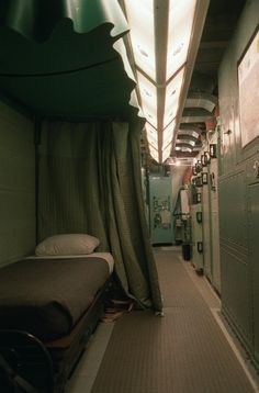 the inside of a train car with a bed and some lockers on each side