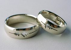 two silver wedding rings sitting next to each other