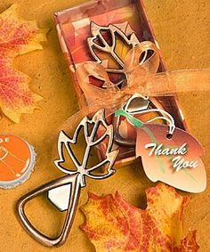 a bottle opener and some autumn leaves on a table with a thank you tag attached to it