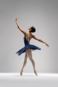 a ballerina in a blue tutu and leotard is posing for the camera