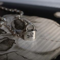 a close up of a chain with a padlock on it and a flower in the middle