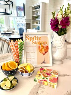 a table topped with plates and bowls filled with fruit next to a sign that says spritz station