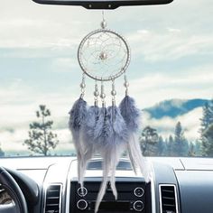 a car dashboard with a dream catcher hanging from the dash