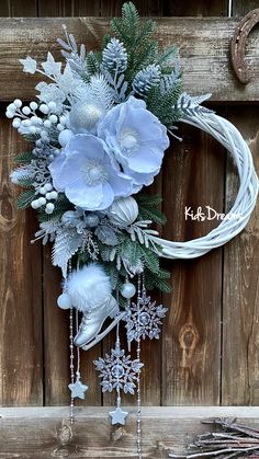 a wreath with flowers and snowflakes hanging on a wooden wall next to other decorations