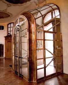 an arched glass door in the middle of a room