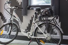 two bikes parked next to each other in front of a wall with black and white designs