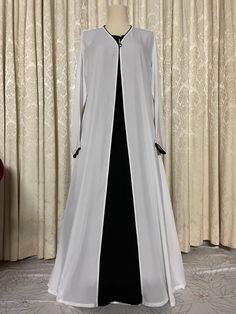 Snow white and black abaya burqa 3-piece set with matching hijab/scarf in high quality fabric, summer friendly, and suitable for all weather conditions.  Abaya white upper cape and hijab is handmade in soft, lightweight, breathable abaya fabric pipened with rich black borders matching under abaya and single button closure Black under abaya is handmade in super soft cotton linen fabric, full sleeved with zippered side pockets and pearl neck button.  Abaya cape and under abaya are detachable, may be worn together or separately, as per choice. Super soft cloth and a simple stylish look. Available in size 52. Long Niqab For Eid, Elegant White Wedding Khimar, Elegant Long White Khimar, Elegant Long Niqab For Eid, Fitted Long Abaya With Dabka Details, Fitted Long Abaya With Dabka, White Dabka Abaya For Eid, White Niqab For Eid, Elegant Long Black Niqab