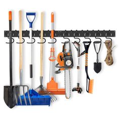 an assortment of garden tools hanging on a wall