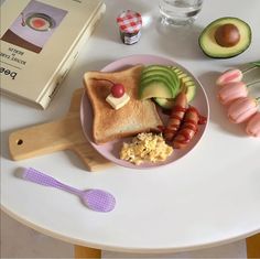 a plate with some food on it next to an open book and utensils