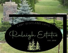 a black sign that says rallight estate ests in front of some trees