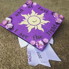 a purple graduation cap decorated with flowers and the words, let's see the light