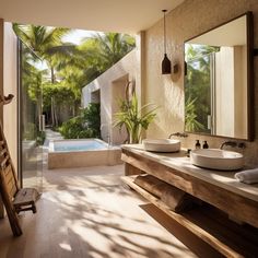 a bathroom with two sinks and a bathtub next to a large window that has palm trees in it