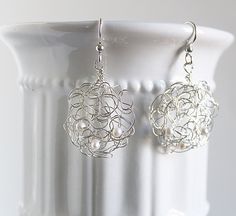 "Do you need a pair of earrings that will go with everything? Or maybe you need a unique gift for someone. You might like these crochet earrings. I have handcrafted these earrings with Argentium silver wire , which is tarnish resistant. I have also added elegant fresh water pearls to enhance the earrings. The earrings hang on sterling silver ear wires. The earrings are 1 \" wide and 1 3/4 \" long from the ear wire. These earrings are also very light in weight. Thank you for visiting my shop. Be Handmade Sterling Silver Dangle Bridal Earrings, Handmade Silver Drop Cluster Earrings, Handmade Silver Pearl Earrings For Wedding, Handmade Silver Cluster Earrings For Wedding, Elegant Silver Beaded Earrings Wire Wrapped, Elegant Silver Beaded Earrings With Wire Wrapping, Silver Cluster Earrings With Pearl Drop For Gift, Elegant Handmade Sterling Silver Beaded Earrings, Handmade Sterling Silver Pearl Earrings For Party