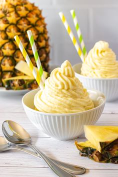 two bowls filled with ice cream next to pineapples