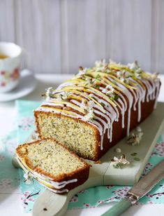 a loaf of lemon poppy seed bread on a cutting board with two slices cut off