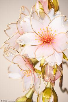 white and pink flowers with gold stems in a vase