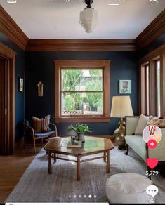 a living room with blue walls and wood trimming on the ceiling is seen in this image