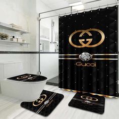 a bathroom with black and gold decor on the shower curtain, toilet seat cover and rug