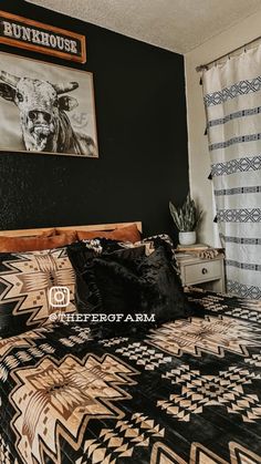 a bed with black and white bedspread next to a painting on the wall