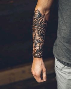 a man with a tattoo on his arm and wrist is holding the hand of another person