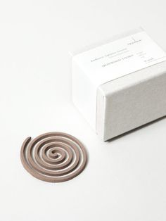 a white box sitting next to a brown and silver object on top of a table