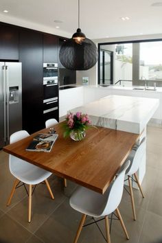 an image of a kitchen with white chairs and a wooden table in front of it