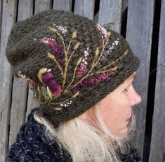 a woman wearing a knitted hat with flowers on it