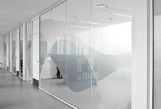 an empty room with glass partitions and white walls