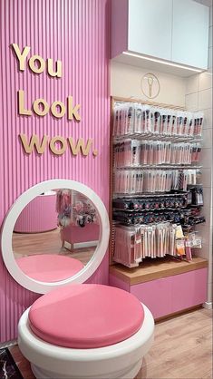 a pink and white chair in front of a mirror with the words you look wow on it