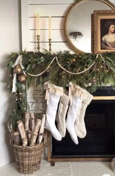 stockings hanging from a mantel decorated with greenery