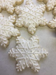 snowflake cookies are arranged on a table