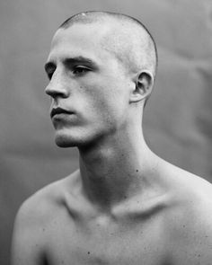 a black and white photo of a man with no shirt on looking off to the side