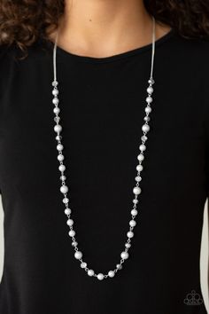 a woman wearing a black shirt and white beaded necklace with silver beads on it