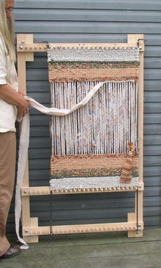 a woman standing in front of a stack of wooden crates with white ribbon tied to them