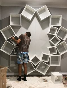 a man is working on a wall made out of bookshelves